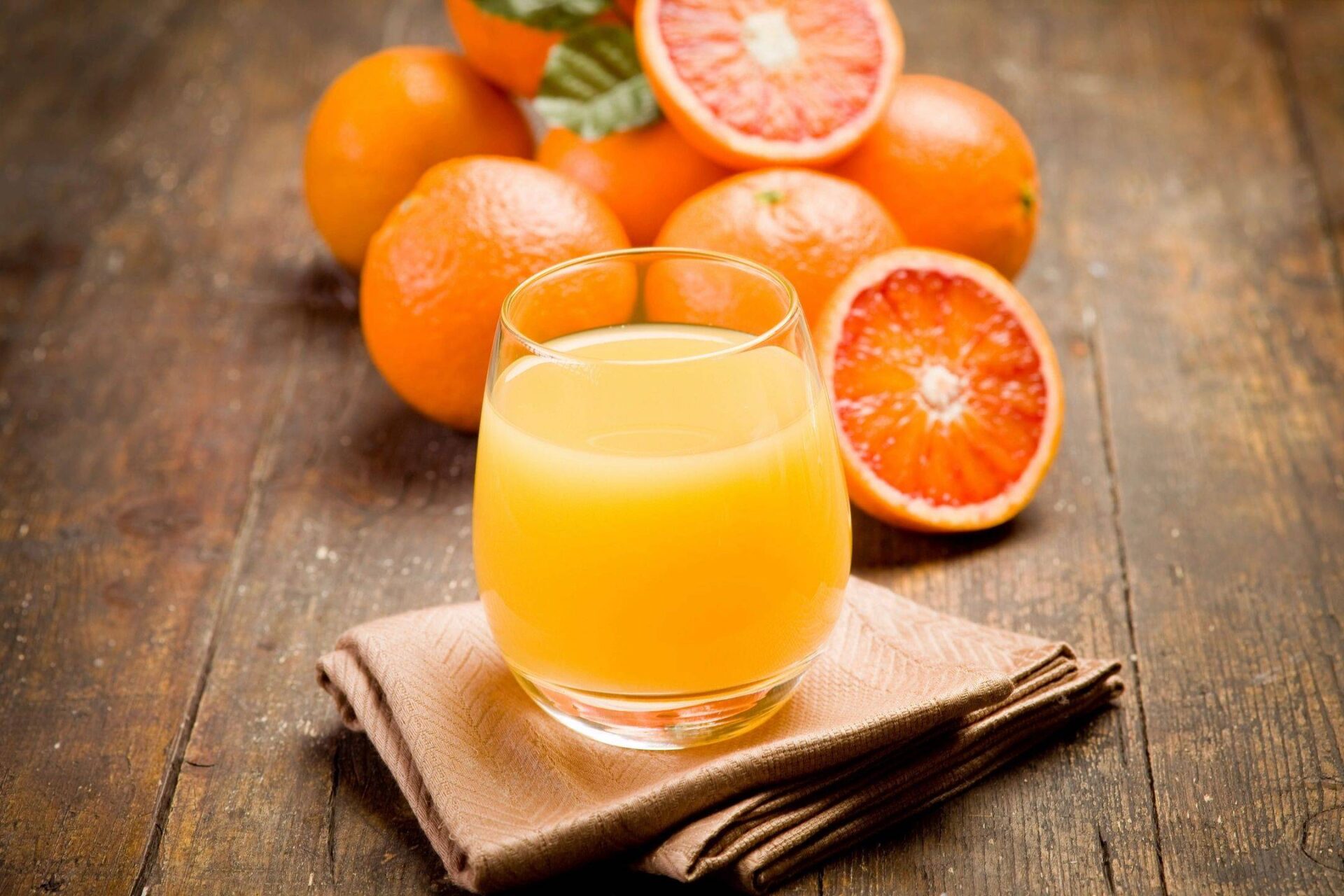 a glass of orange juice and oranges